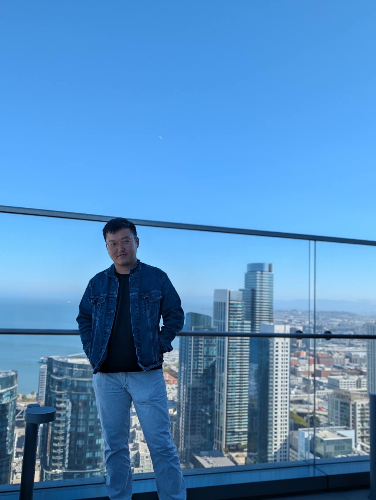 Kang An standing on an observation deck overlooking a city